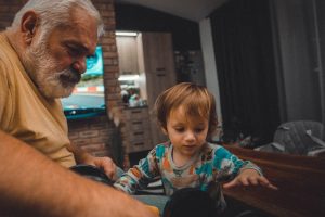 an older man and a young boy playing with a toy car