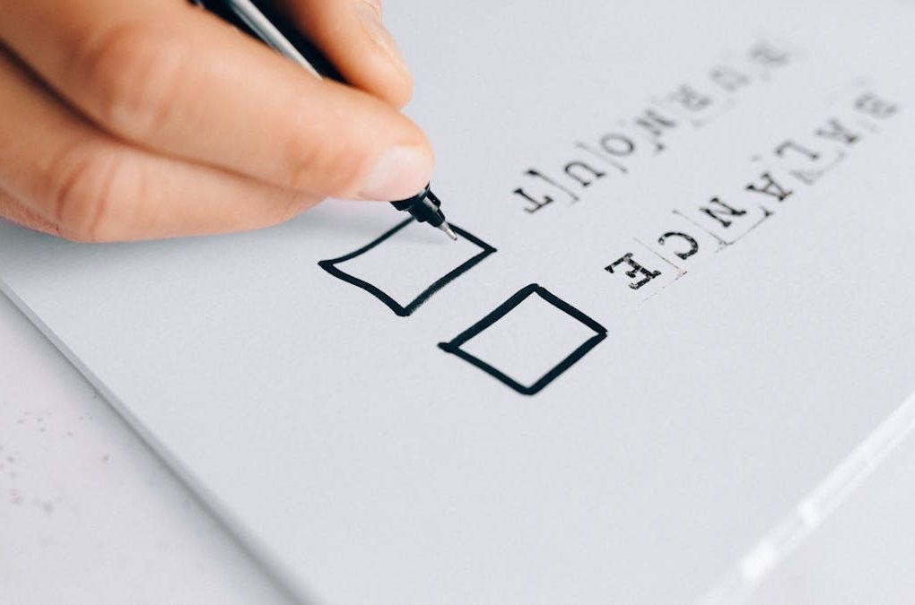 A hand drawing checkboxes on a checklist, themed around balance and burnout.